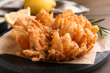 Fried blooming onion served on wooden table, closeup