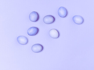 Creatively painted eggs in pastel colors on blue background. Happy Easter concept. Flat lay.