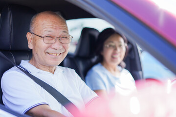 車を運転するおじいさんとおばあさん