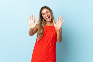 Young hispanic woman over isolated blue background counting ten with fingers