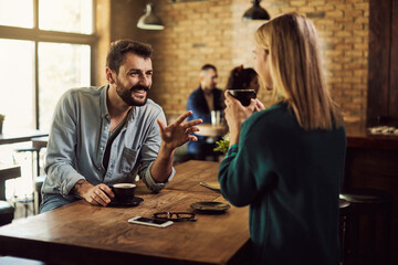 Happy couple talking while drinking coffee in a cafe.