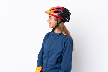 Young hispanic cyclist woman isolated on white background looking side