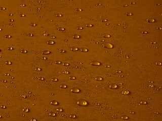 Random water drops on the gold PVC surface