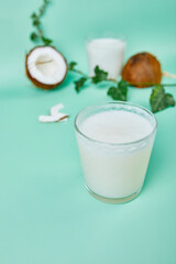 Fresh healthy coconut milk in a glass on blue background,