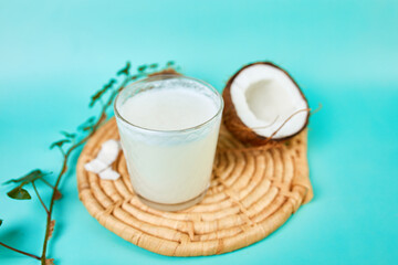 Fresh healthy coconut milk in a glass on blue background,