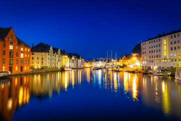 Fototapeta na wymiar Architecture of Alesund city reflected in the water at night, Norway