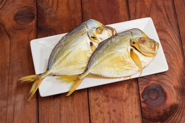 Two smoked Atlantic moonfish on dish on rustic table