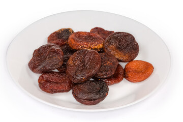 Dried smoked apricots on a white dish, selective focus