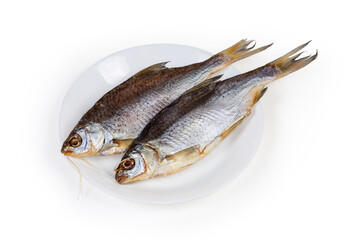 Two salted and dried roach on dish on white background