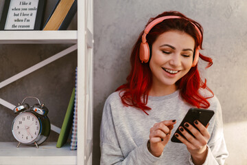 Smiling beautiful woman listening music with mobile phone and headphones