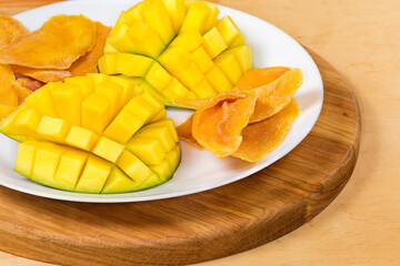 Dried and fresh mango on dish on serving board closeup