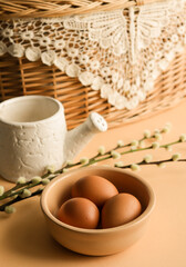 Fototapeta premium Easter eggs in natural color in a ceramic plate with pussy willow branches.
