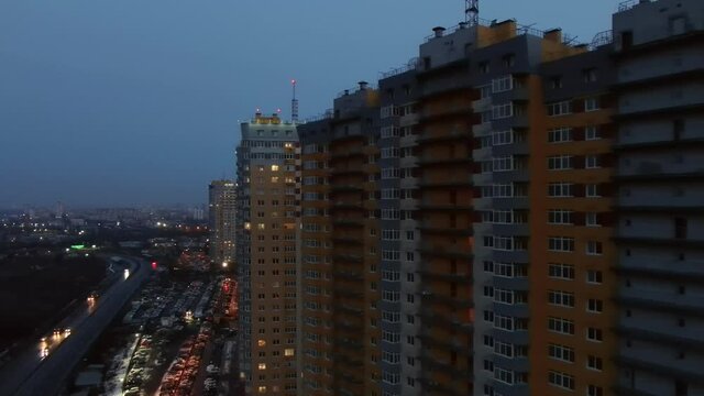Night city. Residential buildings with glowing windows at night