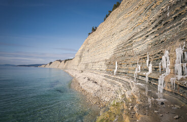 Beautiful landscape sea view. Shore with white pebbles and rocks on a spring day