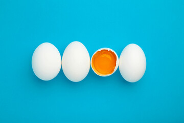 White eggs and egg yolk on the blue background. Easter concept.