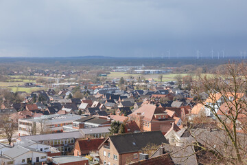 Top view of a German city with white wind turbines in the distance. Energy transition in Europe....