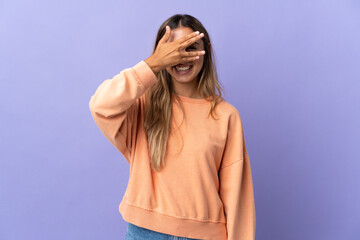 Young hispanic woman over isolated purple background covering eyes by hands and smiling