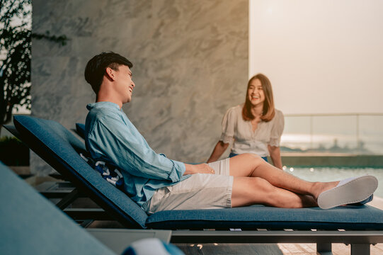 Asian couple talking near pool with perfect sea view.Summer, Vacation,Love couple and sweet  couple concept.