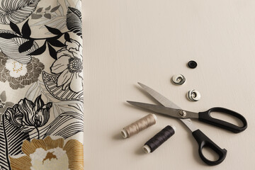 scissors, threads, buttons and fabric on a light background