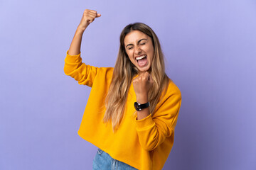 Young hispanic woman over isolated purple background celebrating a victory