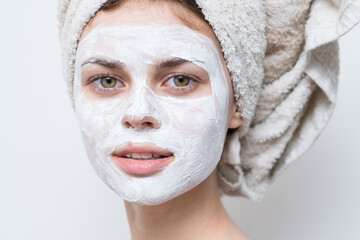 woman with cream on her face towel on her head skin care close-up