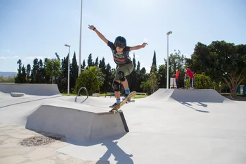 Afwasbaar fotobehang Teenage boy in skateboard park against blue sky © Jose Prieto
