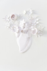 Human heart organ concept with paper flowers as a circulatory anatomy made of paper as a medical health care symbol of an inner cardiovascular body part.