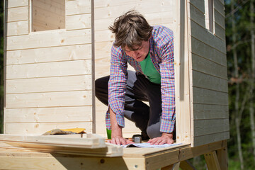 Man reading instructions to build a playhouse