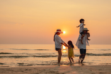 Happy asian family that enjoys beach activities during the summer holidays. parent and children...