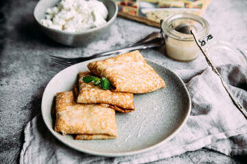 crepes with homemade cottage cheese on a gray plate