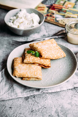 crepes with homemade cottage cheese on a gray plate