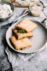 crepes with homemade cottage cheese on a gray plate
