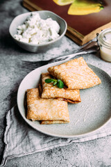 crepes with homemade cottage cheese on a gray plate