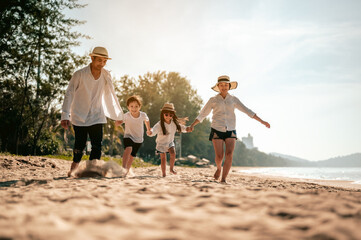 Happy family, Parents are holding hands their children and walking on the beach in holiday.Family, travel, beach, relax, lifestyle, holiday concept.