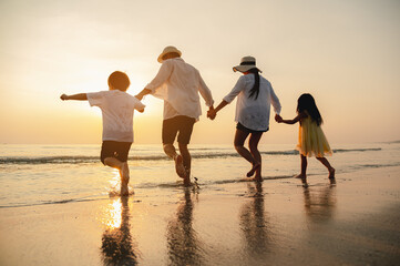 Happy asian family at consisting father, mother,son and daughter having fun playing beach in summer...