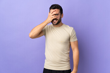 Young handsome man with beard over isolated background covering eyes by hands and smiling