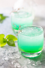 glass of cold drink with fresh mint leaves and ice cubes