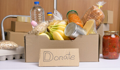 cardboard box with various products, fruits, pasta, sunflower oil in a plastic bottle and...