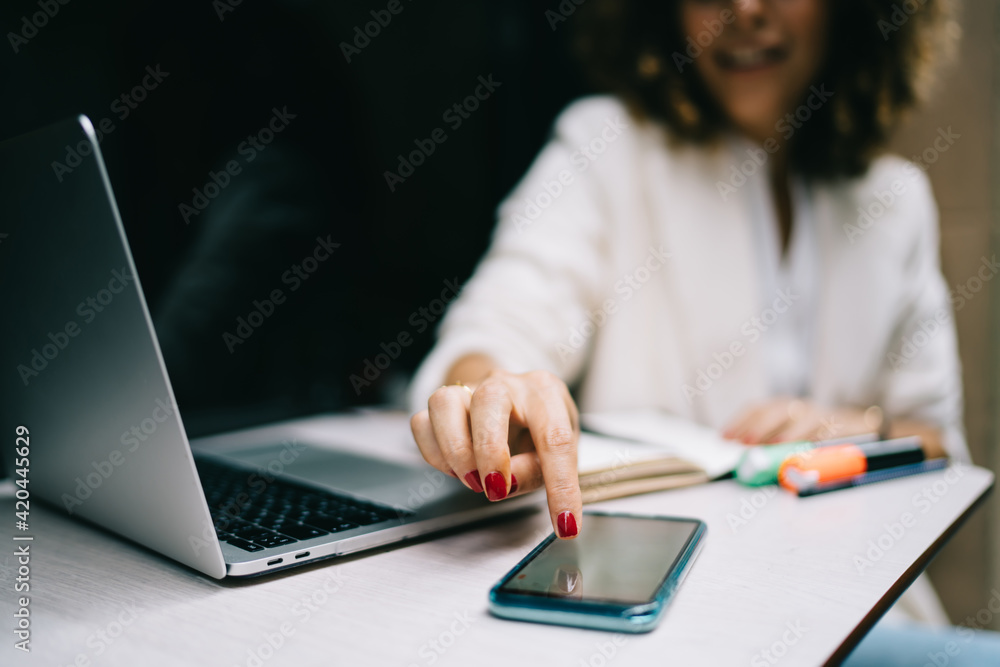Poster selective focus on modern smartphone device used by unrecognizable female freelancer checking receiv