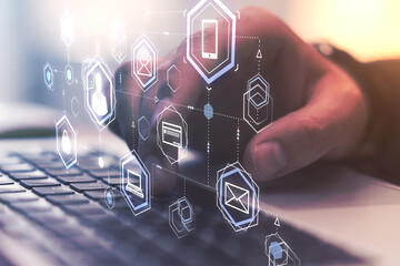Data customer connection concept with hologram social networking icons and man hand typing on laptop keyboard