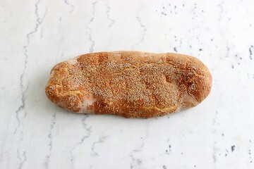 Lagana flatbread with sesame, traditionally eaten on Clean monday in Greece on a white marble...