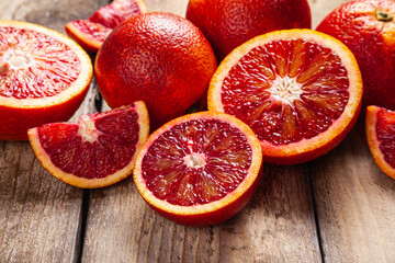 Slices of blood oranges on a wood background. Food background.