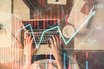 Double exposure of woman hands working on computer and forex chart hologram drawing. Top View. Financial analysis concept.