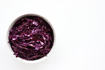 Easy homecooked coleslaw from red cabbage in a bowl on white table background. Top view, copy space. Fresh vegetable salad. Flat lay food. Healthy eating concept
