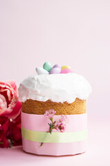 Easter cake and colourful candy  on pastel pink background with copy space . Vertical greeting easter card .