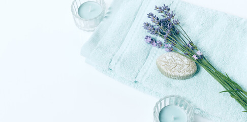 Spa background in pastel blue color, flat lay, towel, soap, lavander flowers