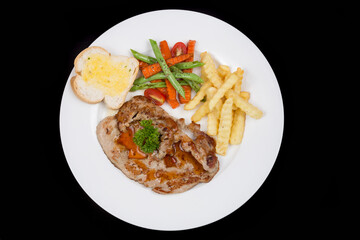 Fried piece of pork with vegetable salad on a plate close-up view from above. horizontal