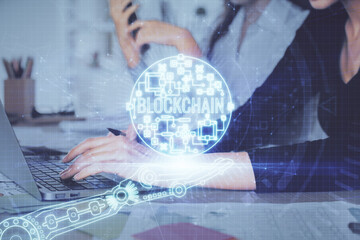 Double exposure of woman hands typing on computer and crypto market theme hologram drawing....
