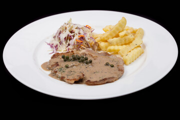 Steak with pepper sauce serve with french fries and salad.