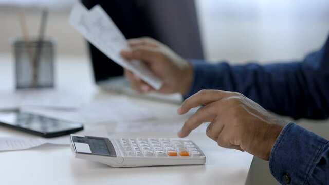 The young man was looking at the bill to calculate his income and expenses. In his hand there were bills to pay a lot in debt.
